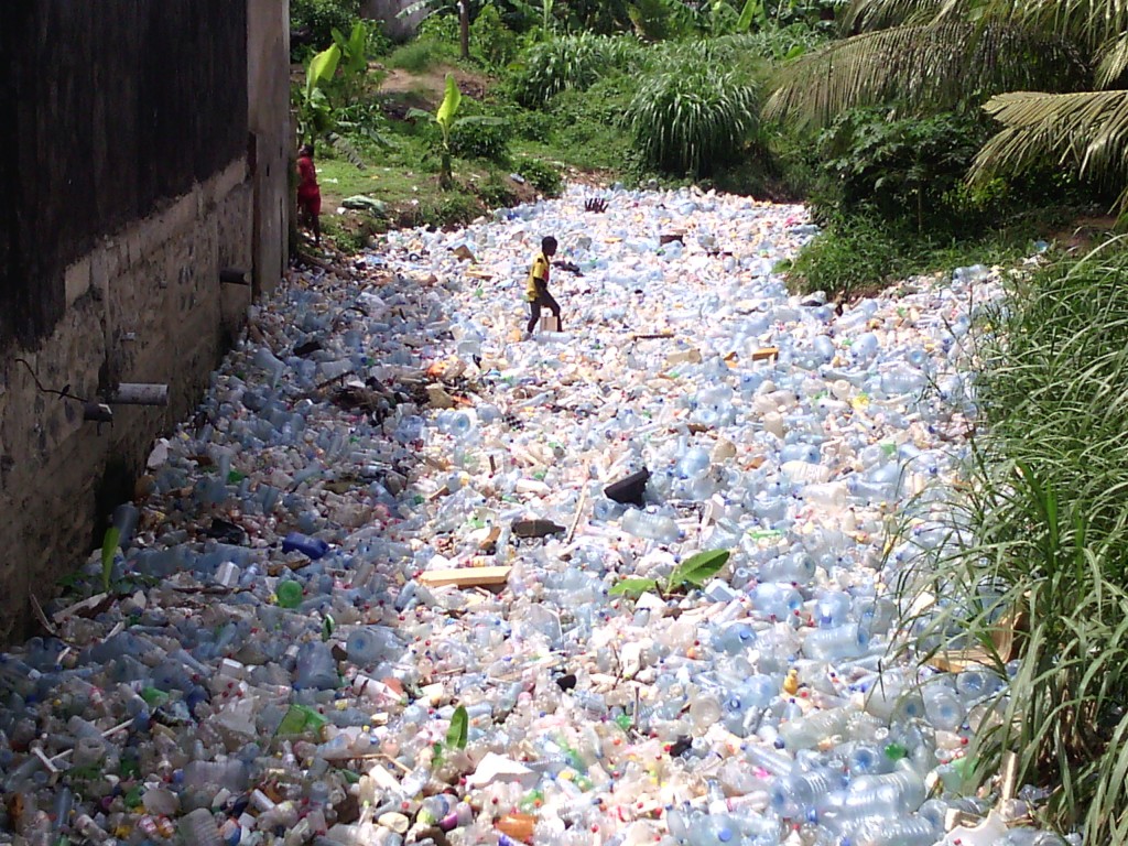Une vue d'un drain obstrué par des bouteilles plastiques au quartier Madagascar à Douala.